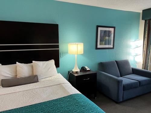 a hotel room with a bed and a chair at Howard Johnson by Wyndham Houston Heights Downtown in Houston