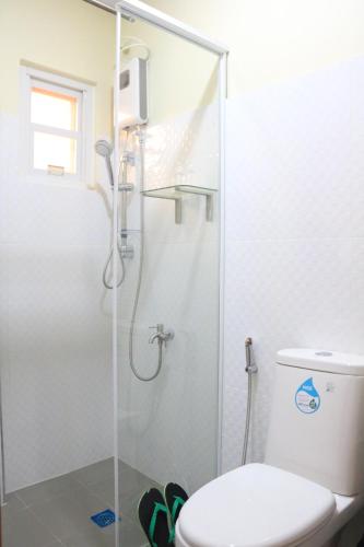 a bathroom with a shower and a toilet at Anicia Guesthouse Units in Manila