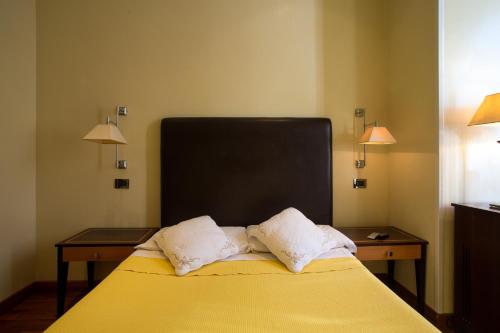 a bed with two pillows on it in a room at Hotel Giolitti in Rome