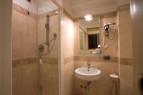 a bathroom with a sink and a shower with a mirror at Hotel Giolitti in Rome