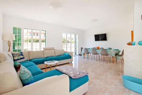 a living room with a couch and a dining room at Villa Domingos by Slow Villas in Calas de Mallorca