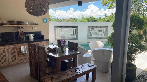 a kitchen and dining room with a table and a pool at Canggu - Pererenan Guesthouse " aBaliHouse " in Canggu