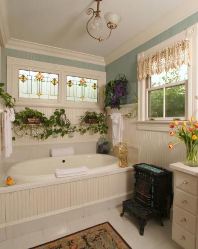 a large bathroom with a tub and windows at White Doe Inn Bed & Breakfast in Manteo