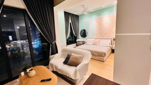 ein Wohnzimmer mit einem Sofa, einem Bett und einem Tisch in der Unterkunft BBCC Apartments At Lucentia in Kuala Lumpur