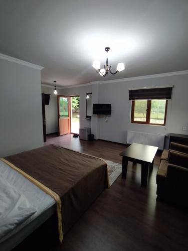 a bedroom with a bed and a table and a couch at Qusar Qala Hotel in Qusar