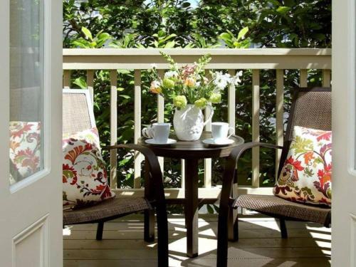 - une table avec un vase de fleurs sur une terrasse couverte dans l'établissement Inn on Randolph, à Napa