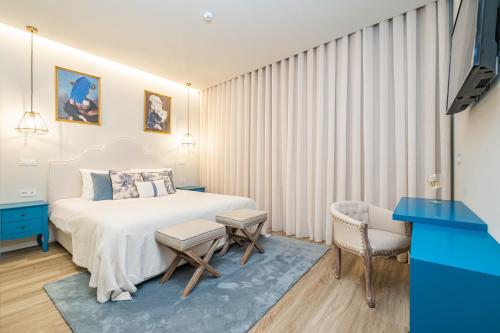 - une chambre avec un lit blanc et un bureau bleu dans l'établissement Machim D'Arfet House by Madeira Sun Travel, à Machico
