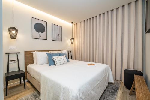 a bedroom with a large white bed and a chair at Machim D Arfet House by Homie in Machico