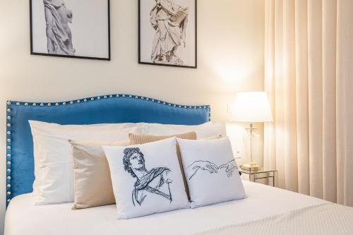 a bed with a blue headboard and white pillows at Machim D Arfet House by Homie in Machico