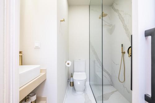 a bathroom with a toilet and a glass shower at Machim D Arfet House by Homie in Machico