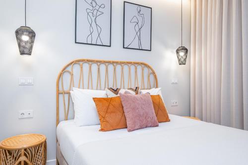 a bedroom with a bed with white sheets and pillows at Machim D Arfet House by Homie in Machico