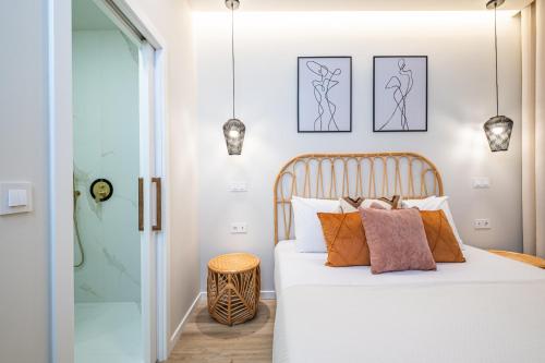 a bedroom with a bed with white sheets and orange pillows at Machim D Arfet House by Homie in Machico