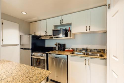 a kitchen with white cabinets and a stainless steel refrigerator at Condo 208 At North Creek Resort in Blue Mountains