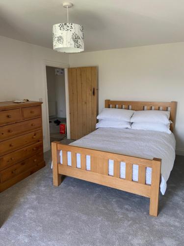 a bedroom with a wooden bed and a dresser at The Farmhouse in Swansea