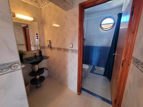 baño con lavabo y aseo y ventana en Good Wave Surf House, en Tamraght Ou Fella