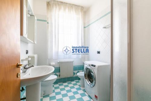 a bathroom with a washer and a washing machine in it at Villa Alpina in Lido di Jesolo