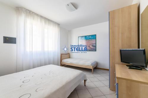 a small room with a bed and a television at Villa Alpina in Lido di Jesolo