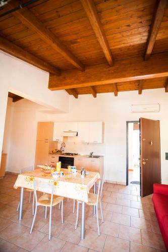 a kitchen with a table and chairs in a room at residence lu soli budoni affitti in Budoni