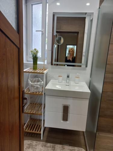 a woman taking a picture of a bathroom with a sink at Guest House Dani in Pomorie