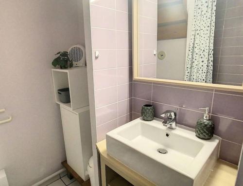 une salle de bain avec un lavabo blanc et un miroir dans l'établissement M-Fairway 01-Moliets Duplex 6 personnes dans résidence avec piscines proche du golf, à Moliets-et-Maa