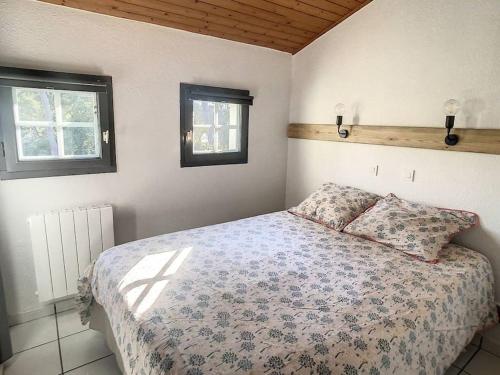 une chambre avec un lit avec deux oreillers dessus dans l'établissement M-Fairway 01-Moliets Duplex 6 personnes dans résidence avec piscines proche du golf, à Moliets-et-Maa