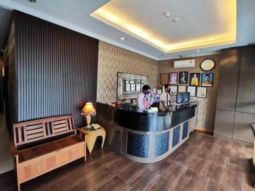 two people standing at a bar in a restaurant at Goodhope Hotel Shah Alam in Shah Alam