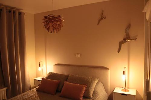 Un dormitorio con una cama con dos luces. en Lucaya, en Koksijde