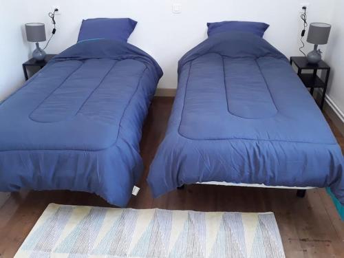 - 2 lits dans une chambre avec couette bleue dans l'établissement Baie de Somme La Haute Valériane, à Saint-Valery-sur-Somme