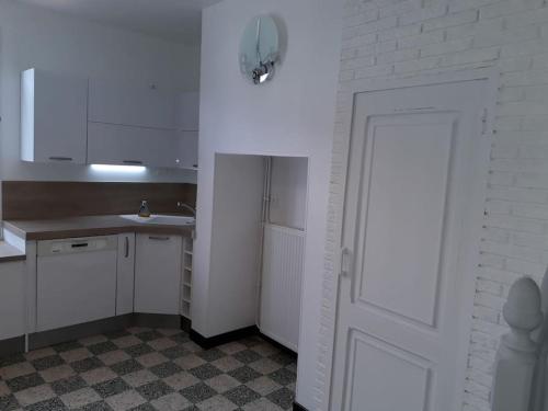 une cuisine avec des placards blancs et une porte blanche dans l'établissement Baie de Somme La Haute Valériane, à Saint-Valery-sur-Somme