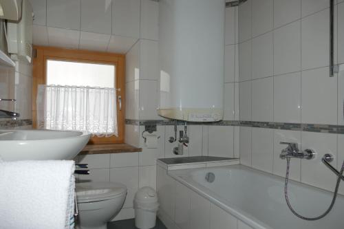 bagno con vasca, lavandino e servizi igienici di Haus Huber, Waltraud Huber a Marquartstein