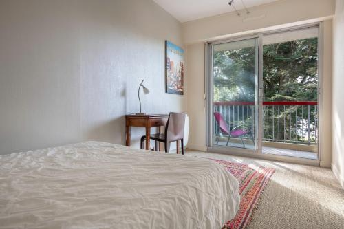 um quarto com uma cama, uma secretária e uma janela em Charmant appartement a 200 m de la mer! em Pornichet
