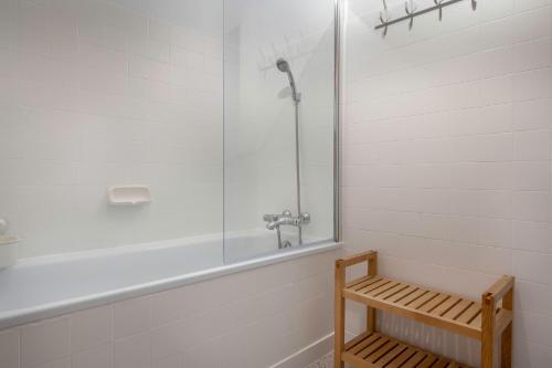 uma casa de banho com um chuveiro e um banco de madeira em Charmant appartement a 200 m de la mer! em Pornichet
