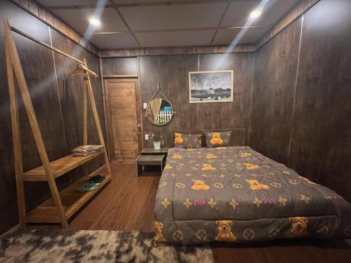 um quarto com uma cama e uma parede de madeira em Thanh Bình Homestay em Khu Chi Lăng