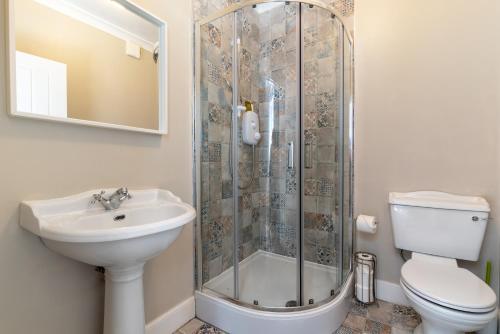 uma casa de banho com um chuveiro, um lavatório e um WC. em Stylish 2 bedroom Cottage near Glasgow Airport em Lochwinnoch