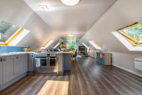 a kitchen with a stove top oven in a room with skylights at Stylish 2 bedroom Cottage near Glasgow Airport in Lochwinnoch