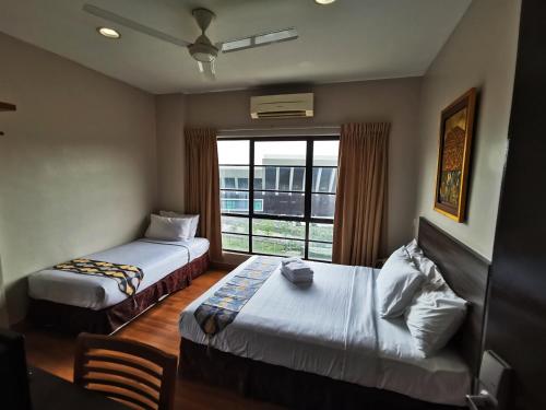 a hotel room with two beds and a window at Goodhope Hotel Shah Alam in Shah Alam