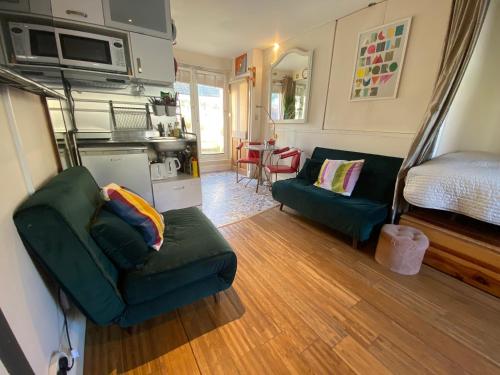 uma sala de estar com um sofá verde e uma cama em Little Western Spa Brighton-Zentrum Beach Apartments em Brighton & Hove