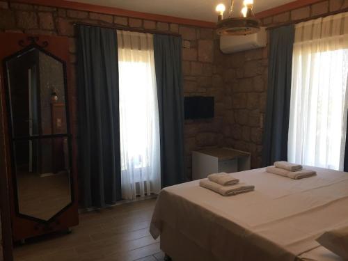 een slaapkamer met een bed met twee handdoeken erop bij Le Petit Hotel ve Bağ Evi in Bozcaada