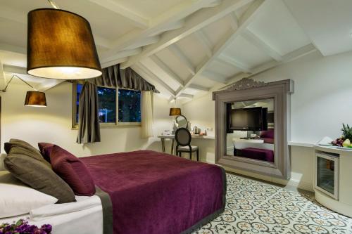 een slaapkamer met een groot bed en een spiegel bij Crystal Aura Beach Resort & Spa - Ultimate All Inclusive in Kemer