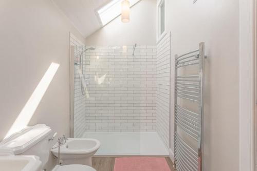 a white bathroom with a shower and a toilet at Stylish self contained studio near Glasgow Airport in Lochwinnoch