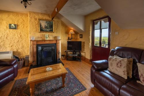 a living room with a couch and a fireplace at Atlantic View Cottages in Doolin