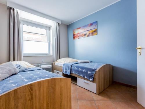 クックスハーフェンにあるHaus Strandnixeのベッド2台と窓が備わる小さな客室です。