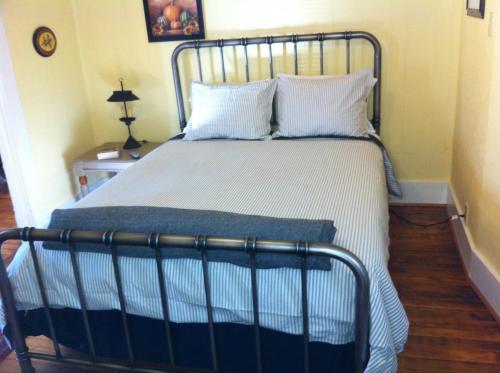 a bed with a metal frame in a room at Brooks House Suites in Mineola
