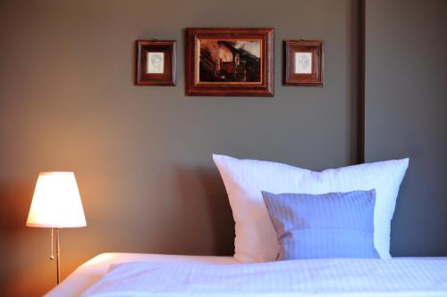 a bedroom with a bed with two pictures on the wall at Hotel Askania 1927 in Bad Wiessee