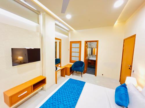 a hotel room with a bed and a tv at Hotel The Orchid Tree Amritsar - walking from Golden Temple in Amritsar