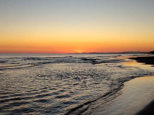 a sunset on a beach with the ocean at Apartament ca l'Irene in Segur de Calafell