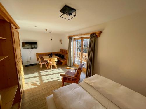 a bedroom with a bed and a living room with a table at Hotel Askania 1927 in Bad Wiessee