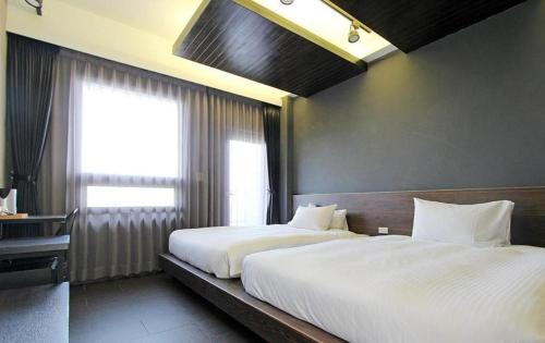 a bedroom with two beds and a window at 窗外的海 - 海洋公園旁 in Yanliau