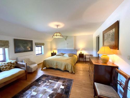 een slaapkamer met een bed, een bank en een tafel bij La ferme du Bailly in Couvin