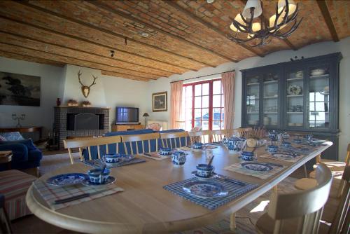een eetkamer met een grote tafel met stoelen en een eetkamer bij La ferme du Bailly in Couvin